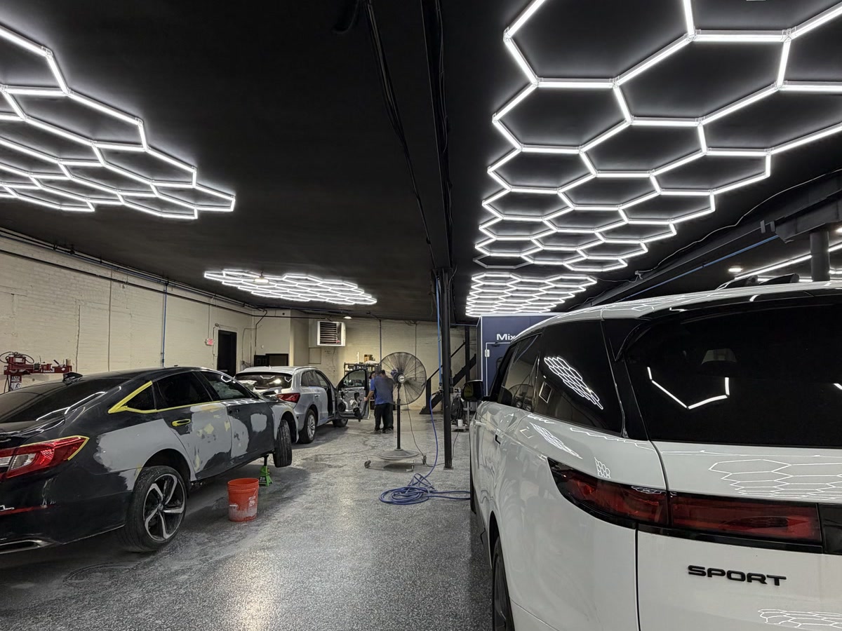 Repair bays at the Waxman shop on Bayview Avenue in Jersey City with cars in different stages of body work
